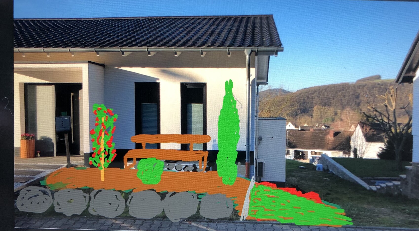 Außenansicht einer weißen Hausfront mit Terrasse; orange Bank, grüne Sträucher und Steinweg im Vorgarten.