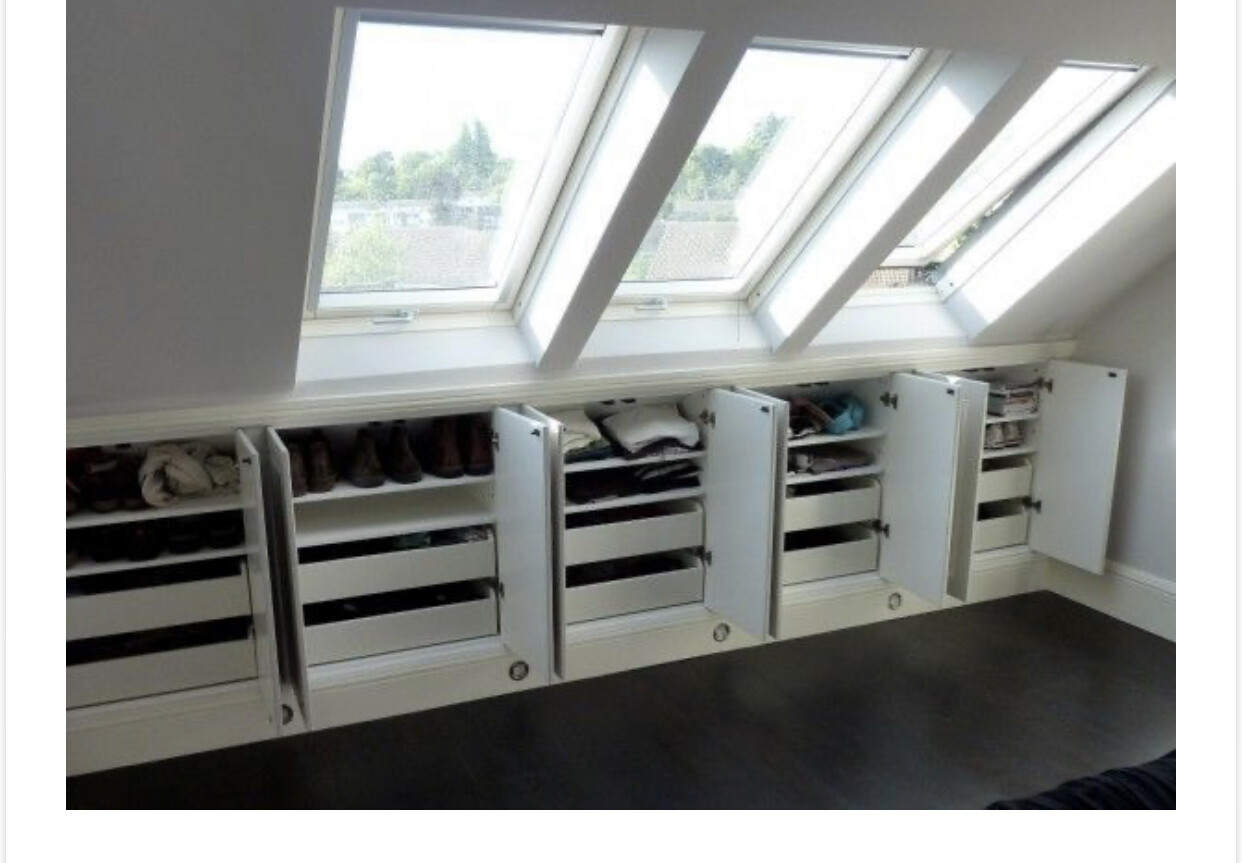 Kleiderschrank mit offenen Türen unter Dachfenstern; Kleidung und Schuhe ordentlich verstaut.