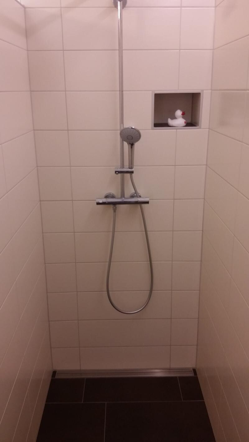 Duschbereich mit Handbrause an vertikaler Stange Nische mit Gummiente