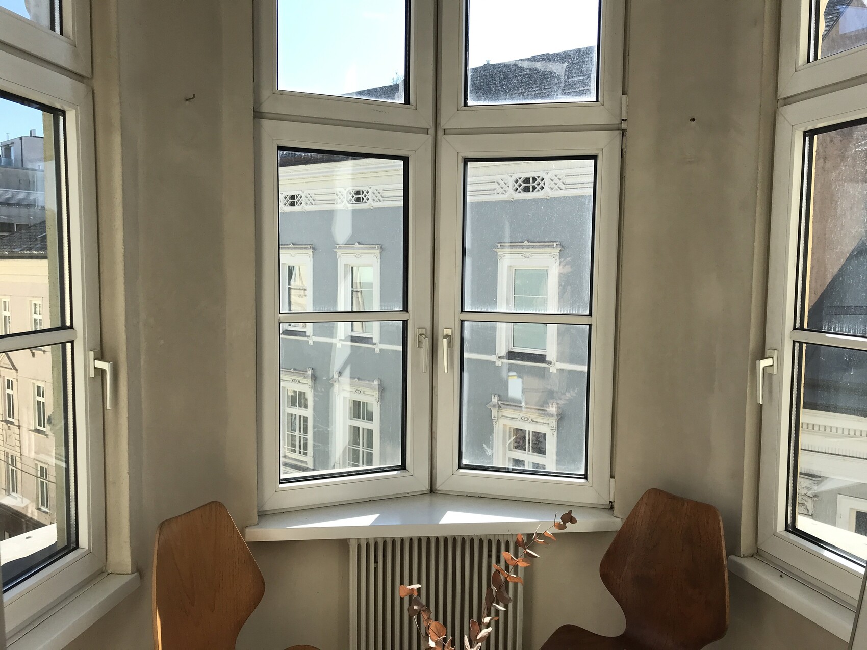 helle-erkerfenster-innenraum-mit-radiator-und-holzstuhle.JPG