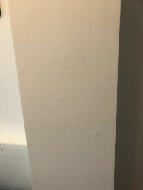 Beige texturierte Innenwand in der Mitte, links weiße Fläche, rechts dunkle Wandkante.