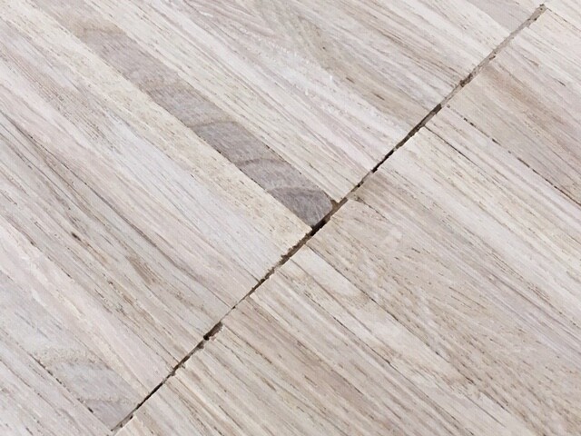 Heller Holzboden aus Brettern mit sichtbarer Fuge und Maserung.