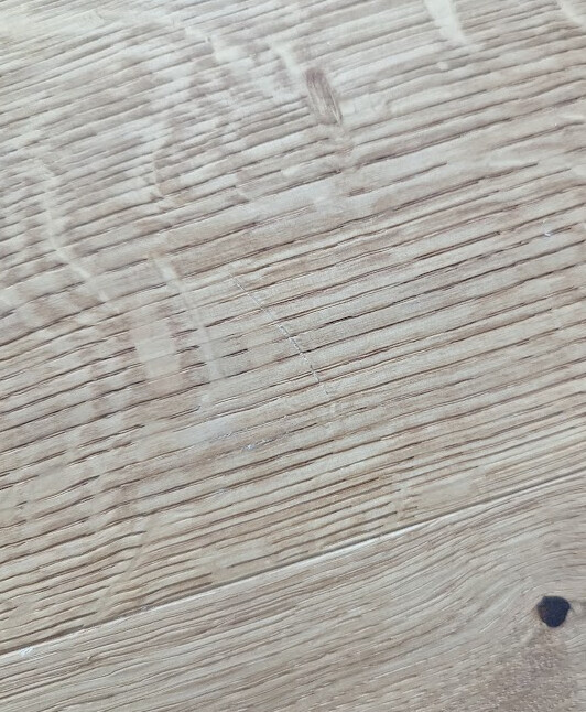 Holzfußbodenplatte mit sichtbarer Maserung und kleinem dunklen Knoten