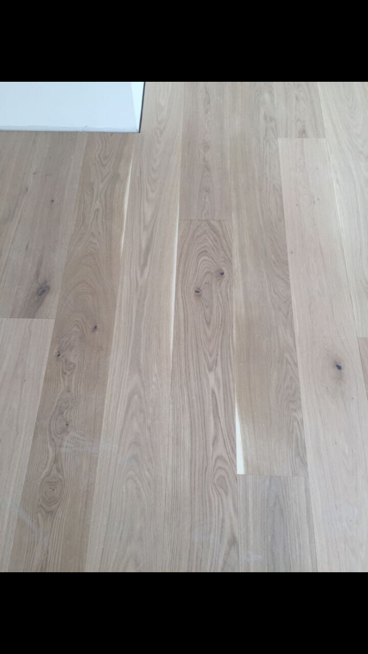 Heller Holzboden mit Maserung und sichtbaren Holzdielen im Innenraum.