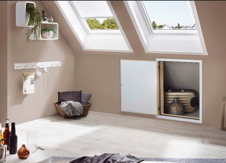 Helles Dachgeschosszimmer mit zwei Dachfenstern, Korb mit Decke und Regal mit Pflanzen.
