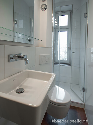 Helles Badezimmer mit Waschbecken, Toilette und Eckdusche