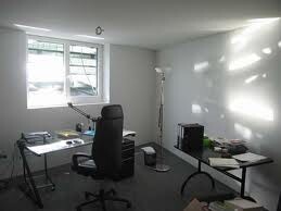 Helles Heimbüro mit Schreibtisch, Stuhl und Fenster in hellem Raum