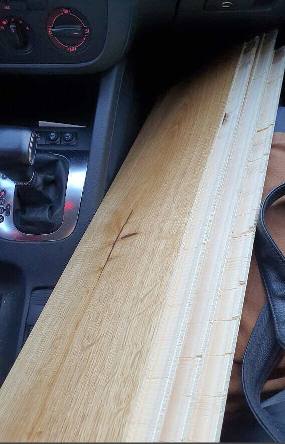 Holzlatten liegen quer im Auto neben dem Schalthebel.