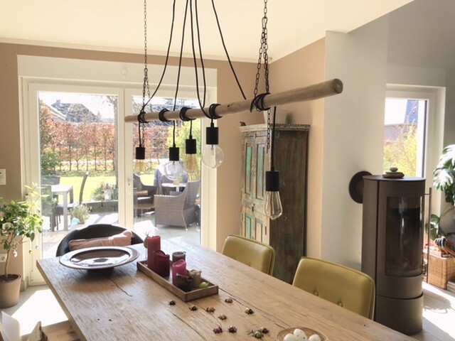 Helles Esszimmer: Holztisch, gelbe Stühle, Holz-Hängeleuchte; Blick nach Garten.