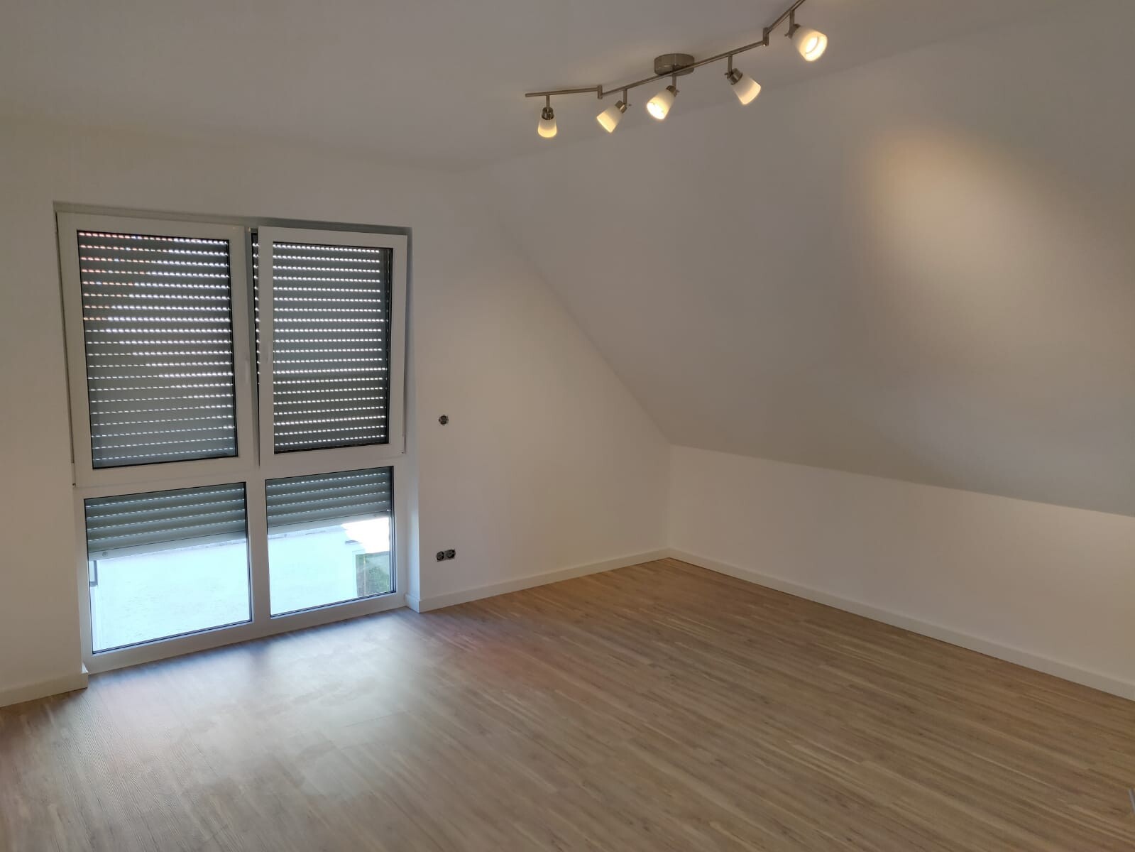helles-wohnzimmer-mit-schraege-decke-und-parkettboden.jpeg