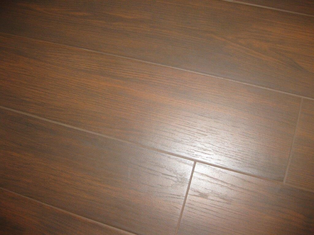 Holzoptik-Laminatboden mit braunen Dielen und leichtem Glanz.