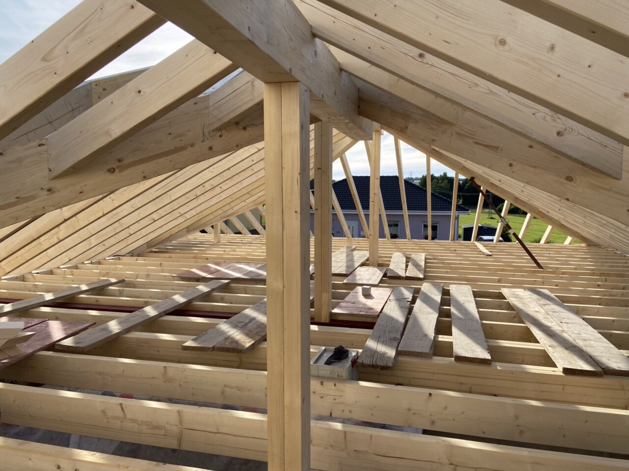 Holz-Dachstuhl im Rohbau mit Sparren, Balken und Bodenbrettern