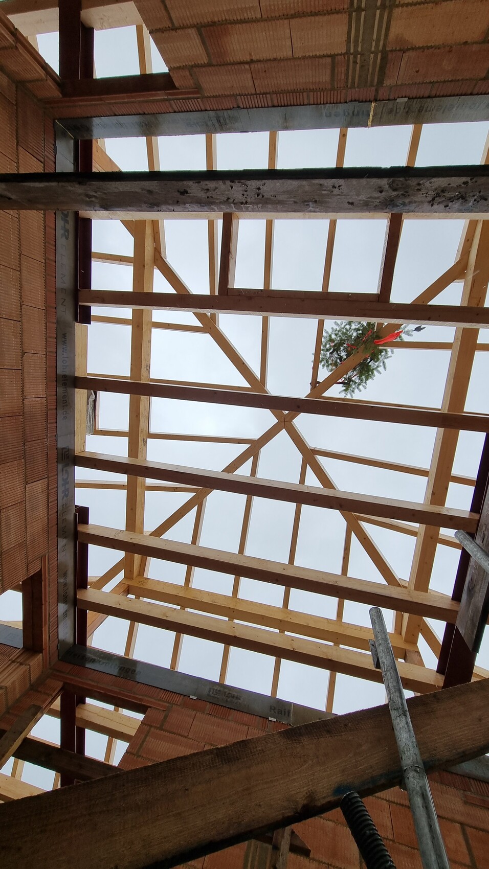 Baustellenaufnahme einer Holzdachkonstruktion mit Rahmenbalken im Rohbau, Blick nach oben