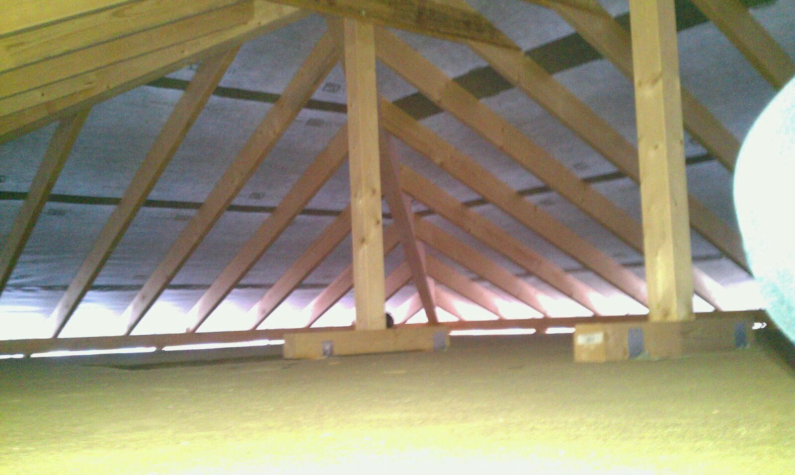 Dachstuhl aus Holz mit sichtbaren Sparren und Balken im Dachgeschoss