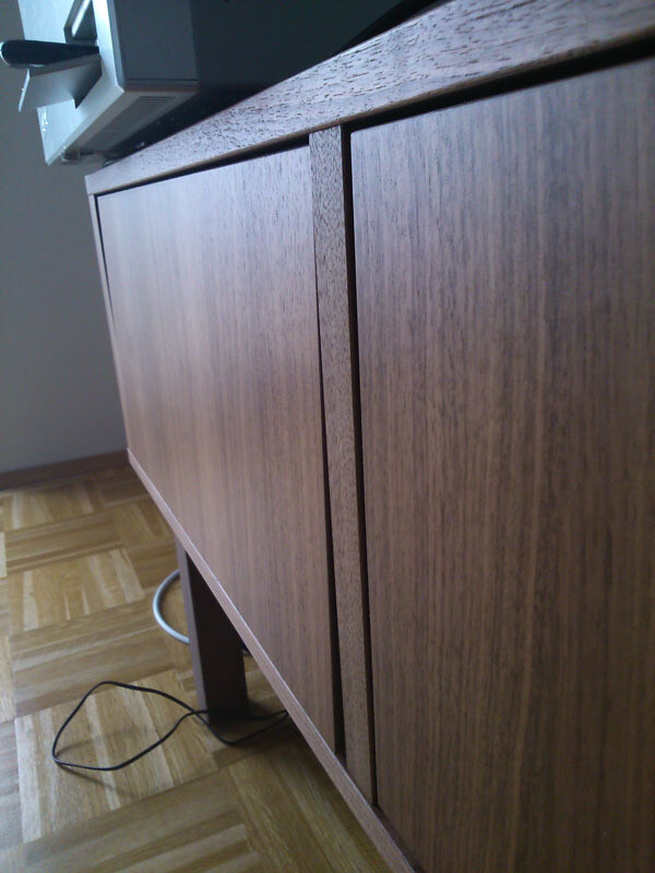 Nahaufnahme eines holzoptik-Unterbauschranks in einer Wohnküche, Kabel am Boden