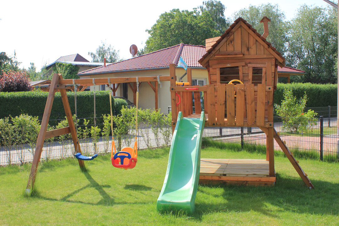 Holz-Kinderspielanlage mit Rutsche und Schaukel im Garten