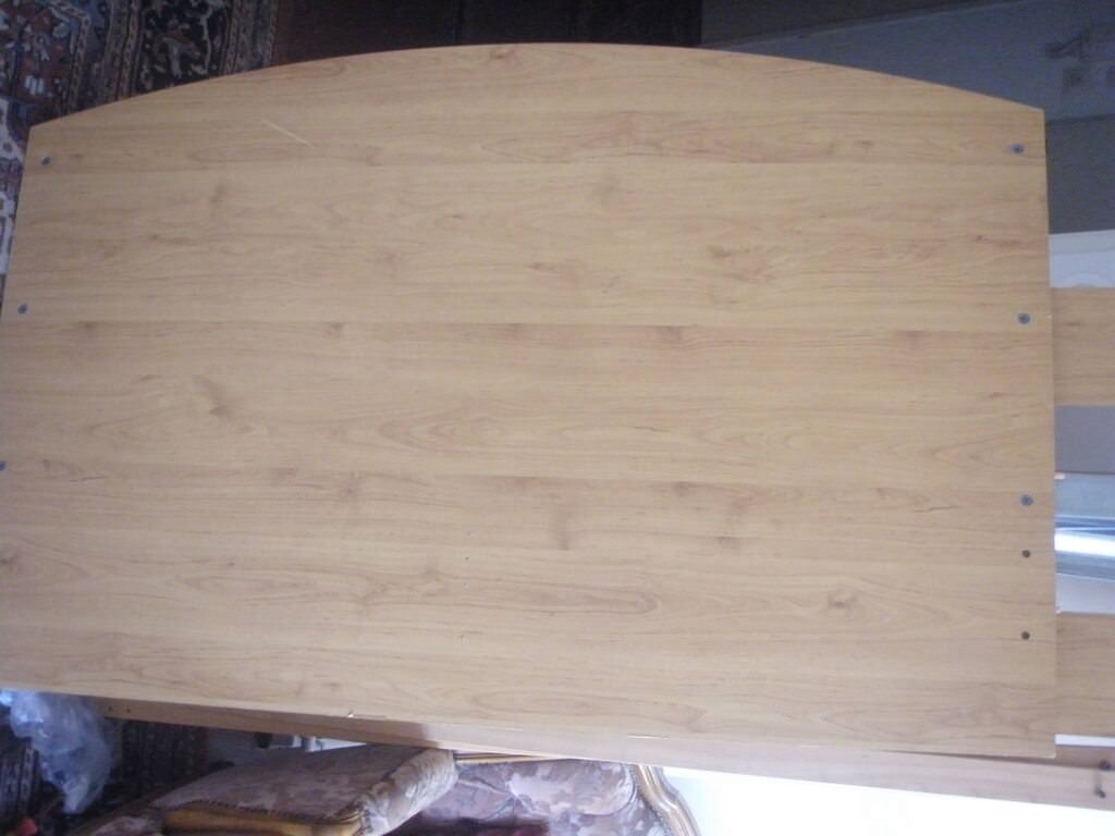 Holz-Tischplatte mit heller Maserung und sichtbaren Schraubnägeln an der Kante