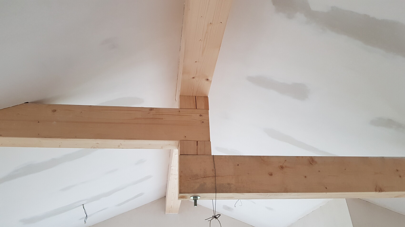 Innenraum mit sichtbaren Holzbalken und Deckenbereich im Innenausbau