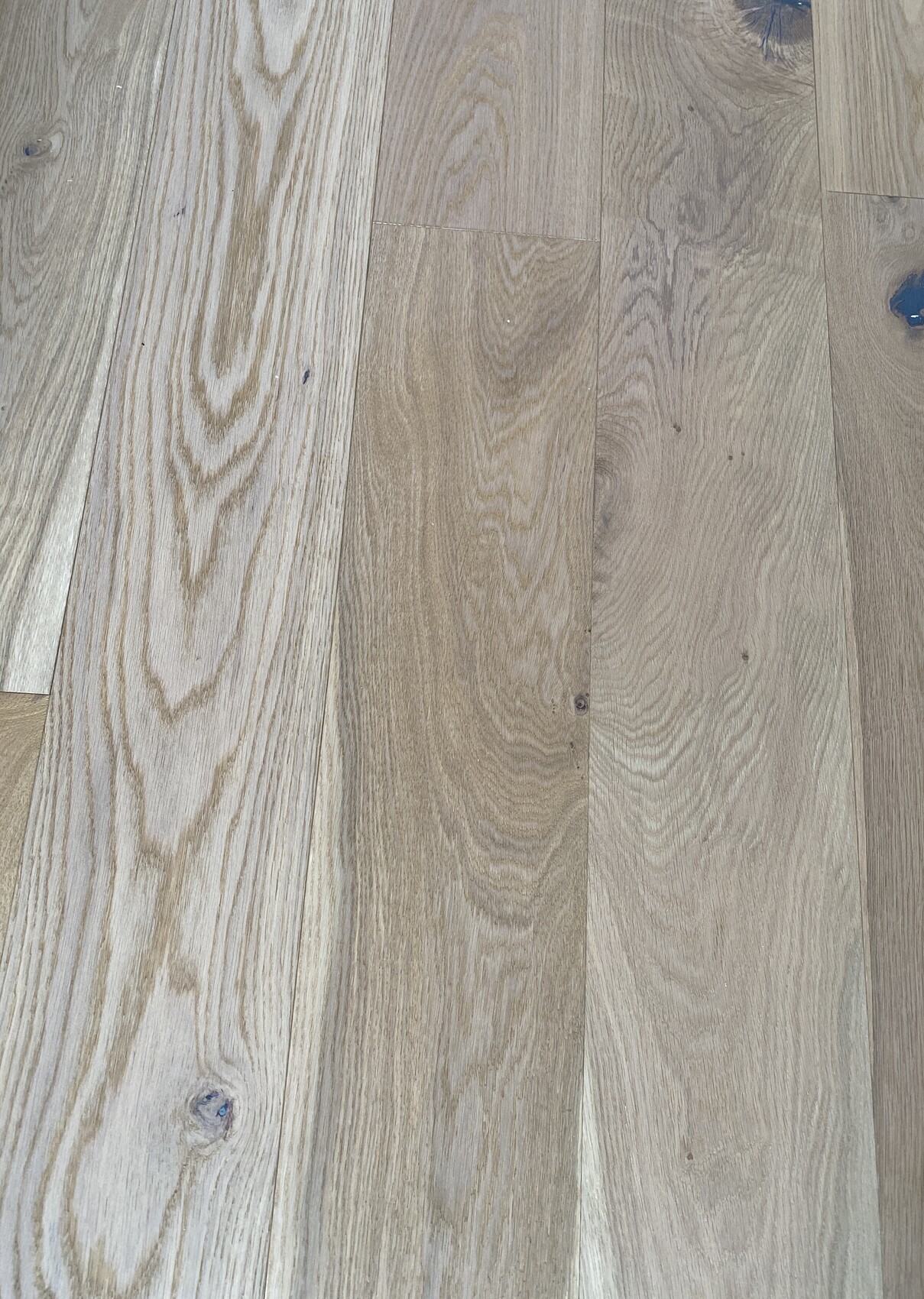 Heller Holzboden aus Dielen mit deutlich gezeichneter Maserung und Knoten.
