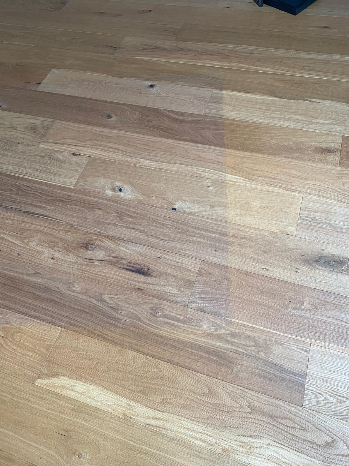 Holzfußboden mit sichtbarer Maserung, Knoten und Farbunterschieden.