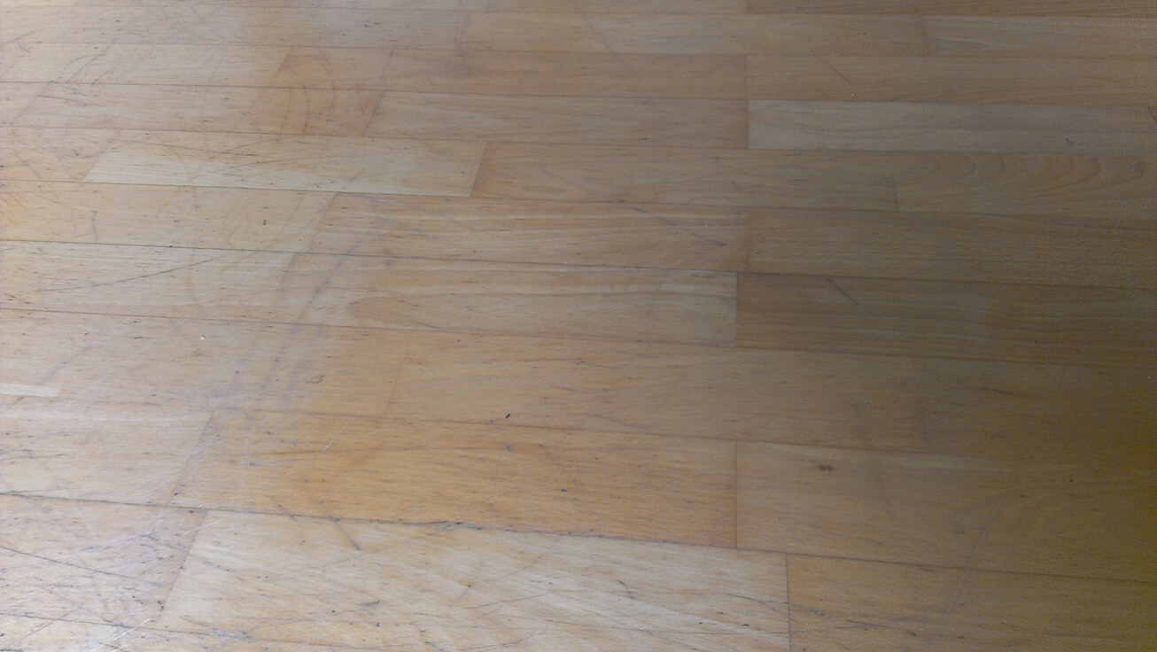 Holzfußboden mit Kratzern und Staubspuren auf Holzdielen