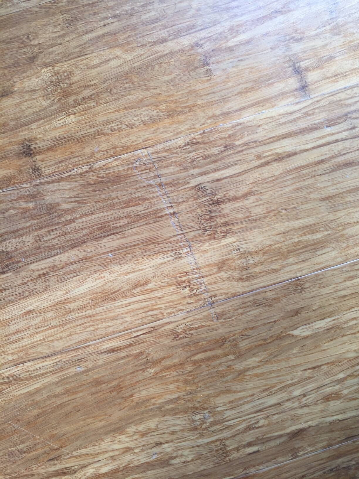 Nahaufnahme einer Holzbodenfläche mit Maserung, Planken und Kratzern.