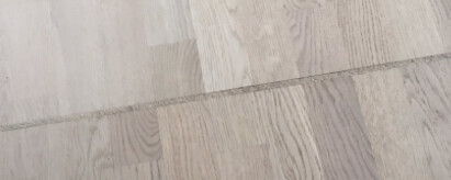 Nahaufnahme eines hellgrauen Holzbodenplankenbodens mit Maserung