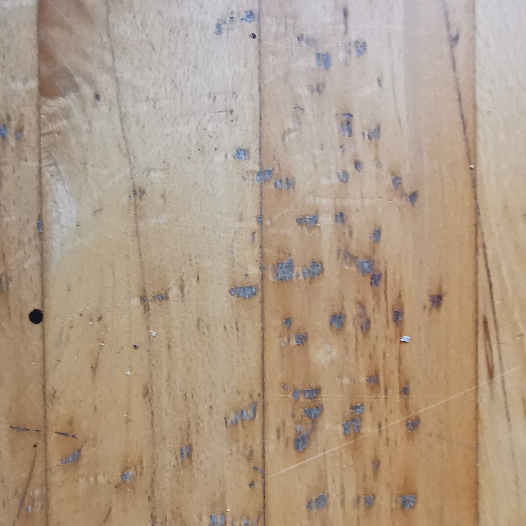 Holzboden aus Holzbrettern mit verstreuten blauen Farbflecken