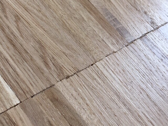 Nahaufnahme von Holzdielen mit Maserung und einer schmalen Fuge.