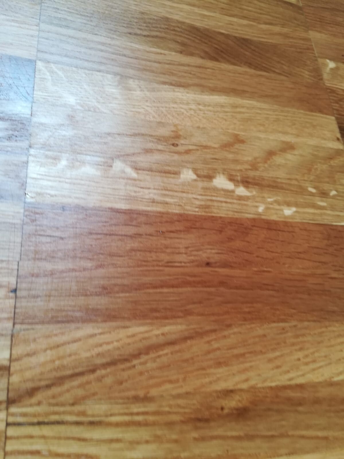 Holzboden mit verschlissener Lackschicht, Abplatzungen und Kratzern