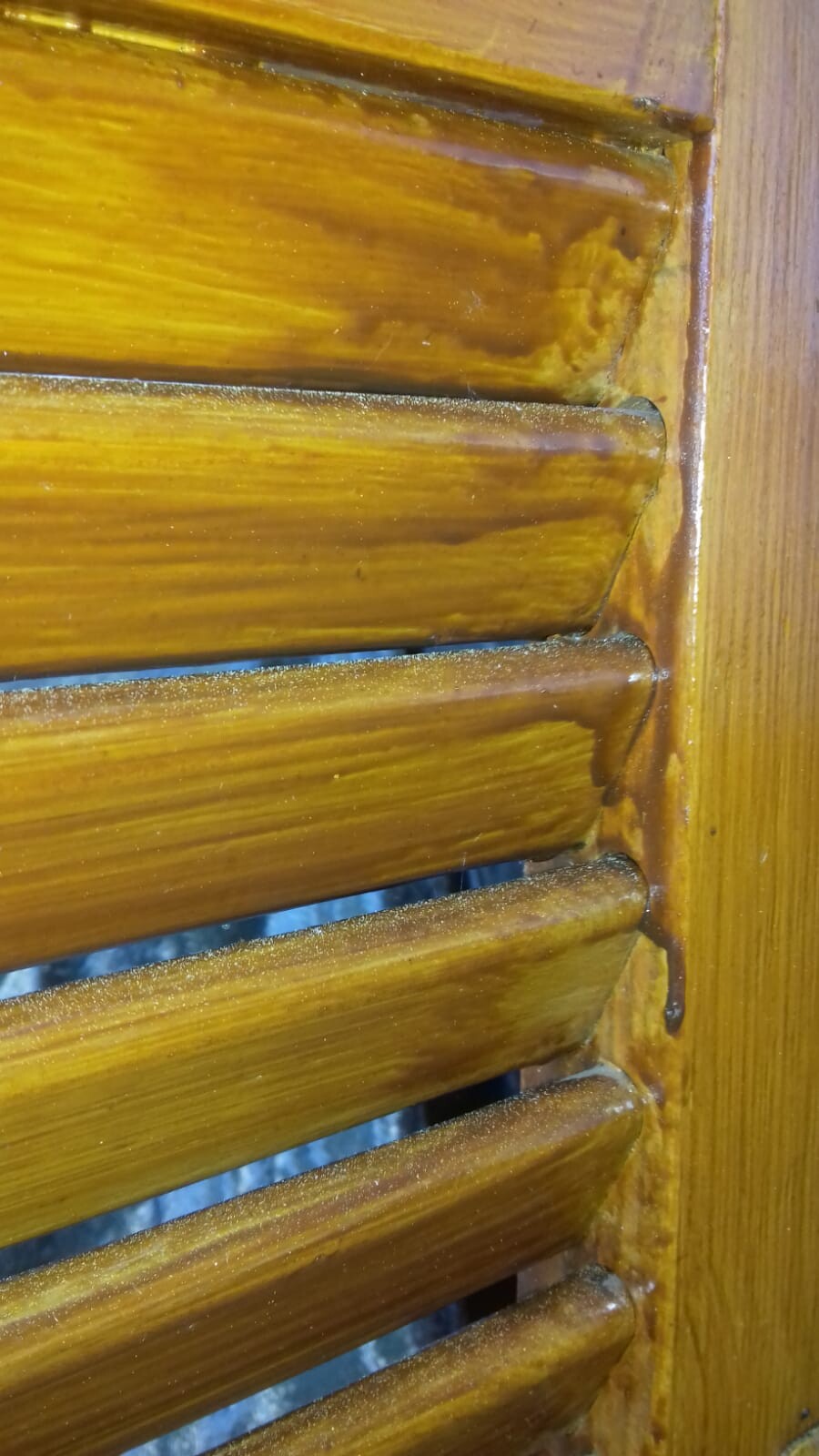 Nahaufnahme brauner Holz-Jalousie mit waagerechten Lamellen und Seitenrahmen.
