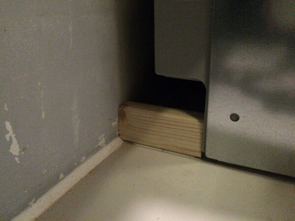 Nahaufnahme eines Holzkeils unter einem Metallgerät im Küchenbereich