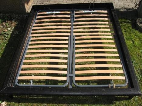 Zweigeteiltes Lattenrost-Bettgestell liegt auf Gras im Außenbereich.