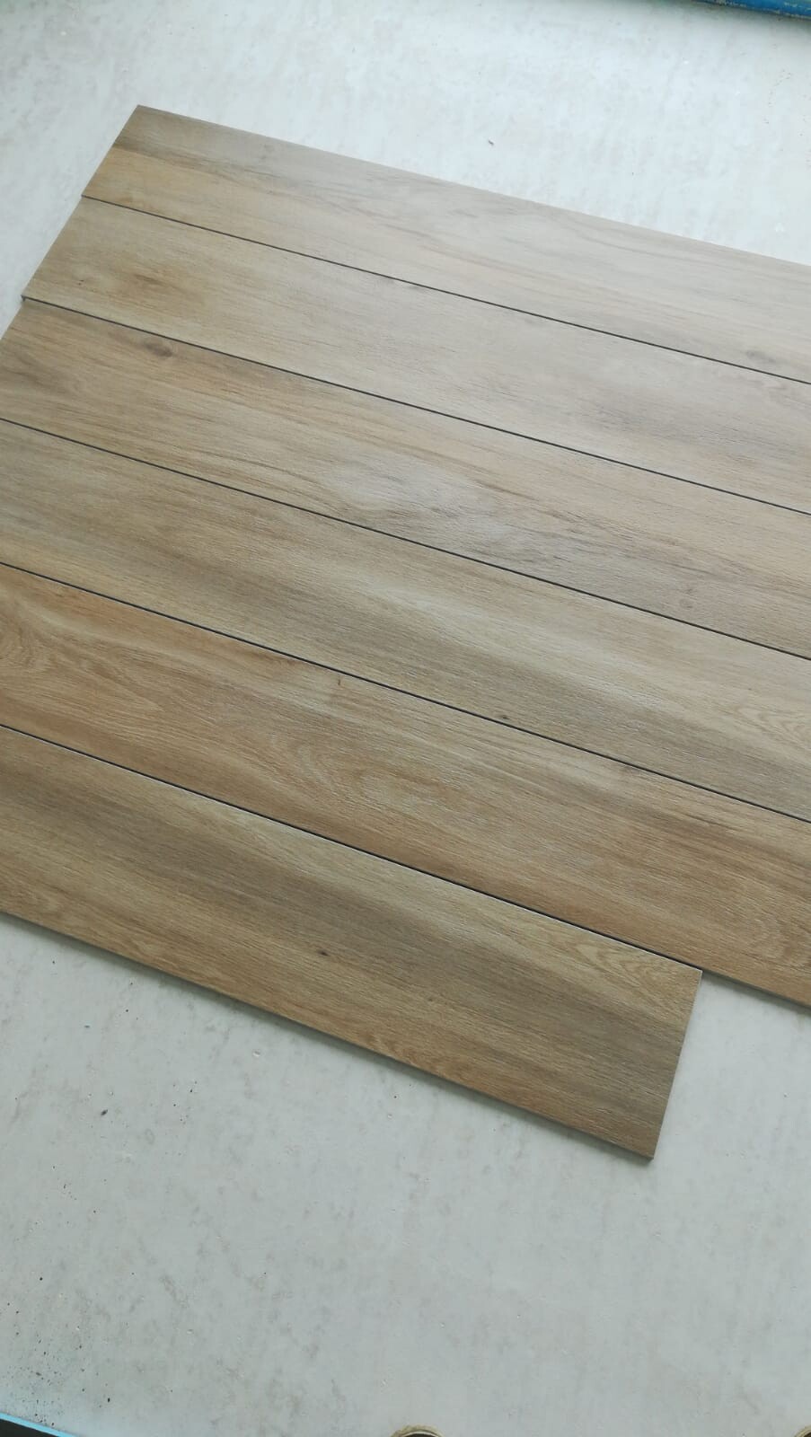 Mehrere hellbraune Holz-Dielen liegen nebeneinander auf einem weißen Untergrund.
