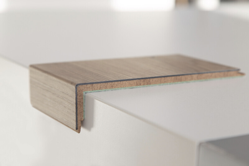 Nahaufnahme eines Holzoptik-Kantenbands auf einer weißen Arbeitsplatte