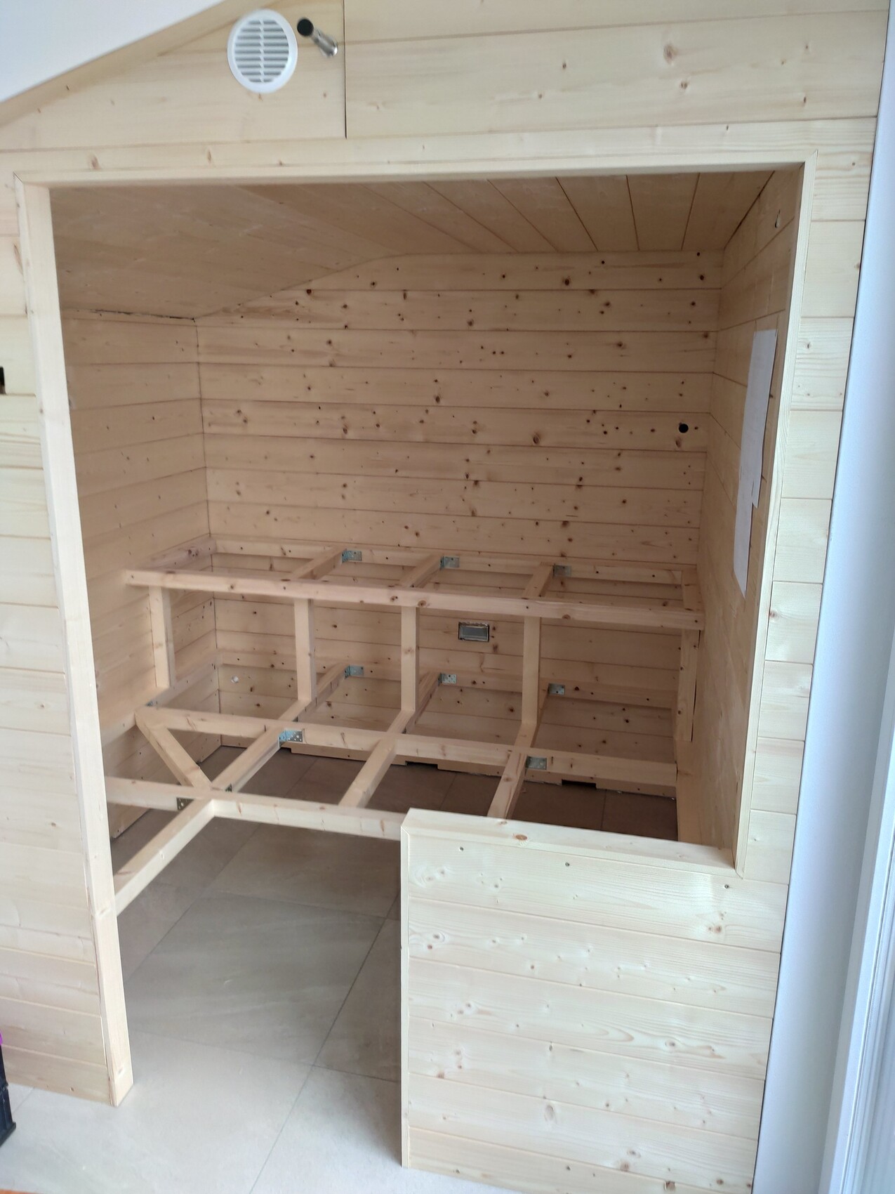 Heller Holzsauna-Innenraum mit unfertigen Holzbankgestellen aus Holzbalken