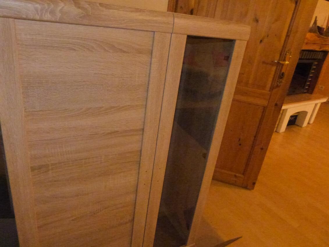 Hölzerner Schrank mit Glasfront in rustikalem Innenraum eines Holzhauses