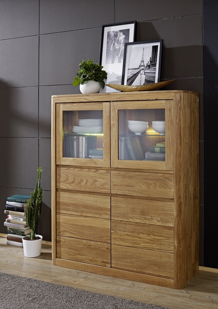 Holzsideboard mit zwei Glasfronten, oben Bilderrahmen, Pflanze und Schale; darunter Schubladen.