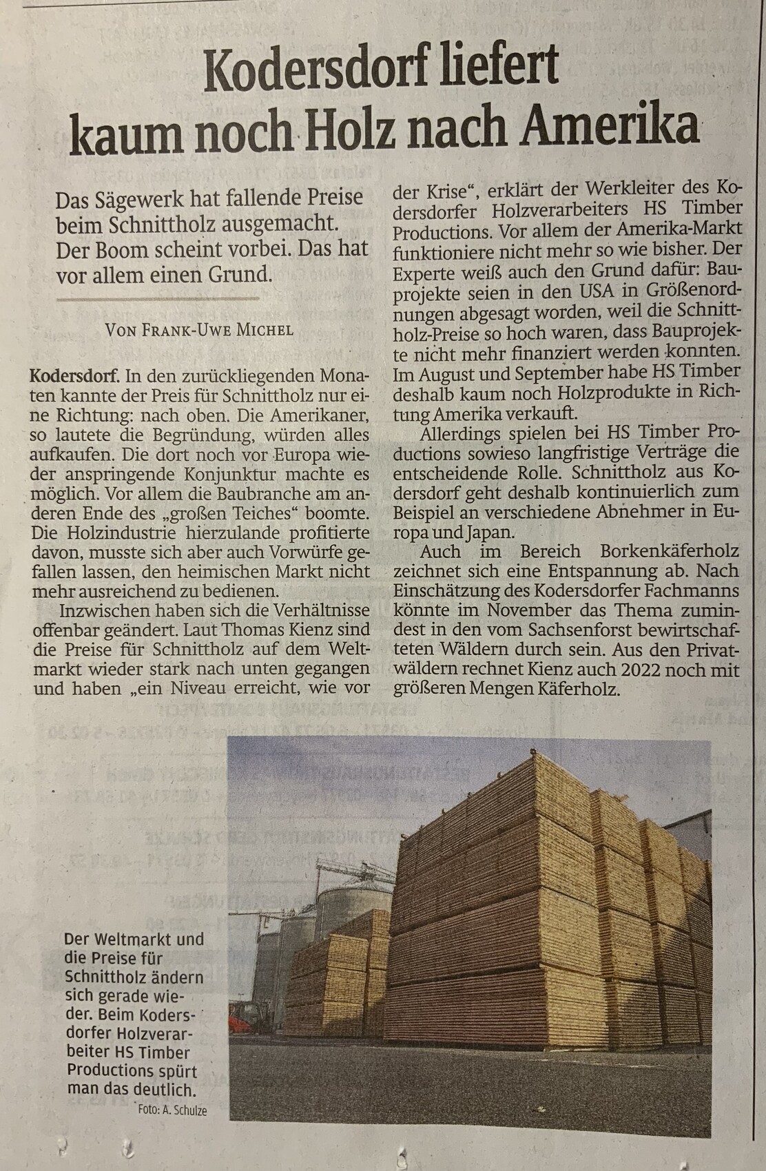 Mehrere gestapelte Holzbalken und Bretter in einem Holzlagerhof, bereit für den Rohbau.
