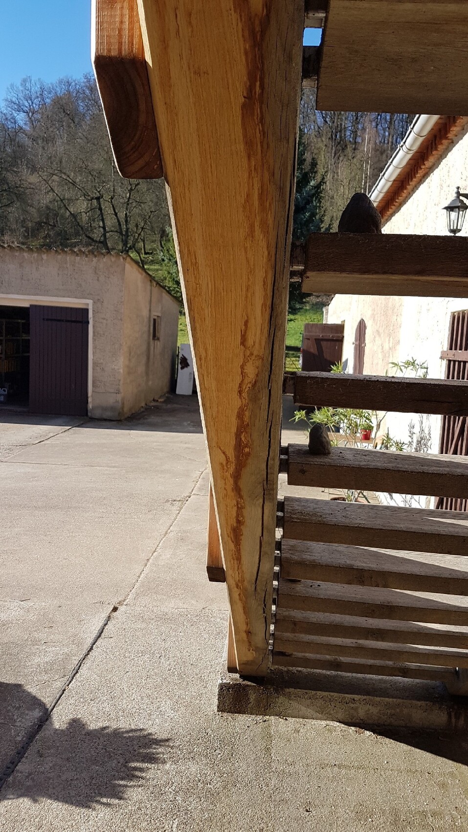 Außenbereich mit robuster Holztreppe und Geländer, Garagen- und Hausansicht im Hintergrund