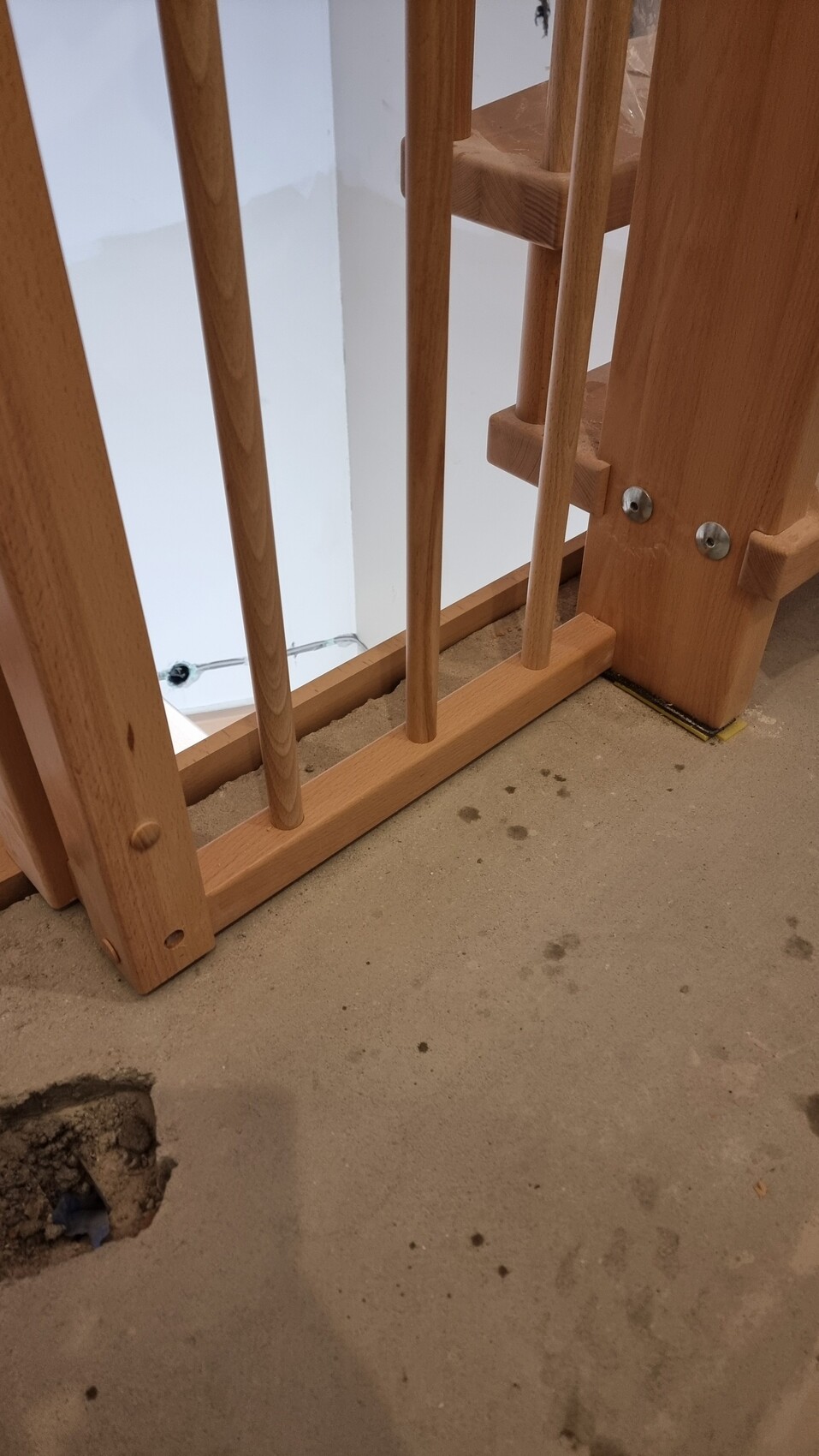 Holztreppe mit Geländerstangen, Baufortschritt, Betonboden mit Loch links unten.