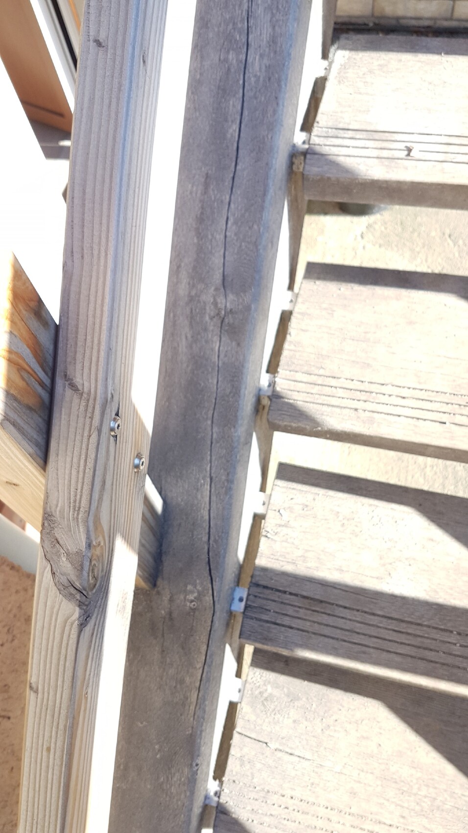 Holztreppe am Bau mit Geländer und Schraubverbindungen.