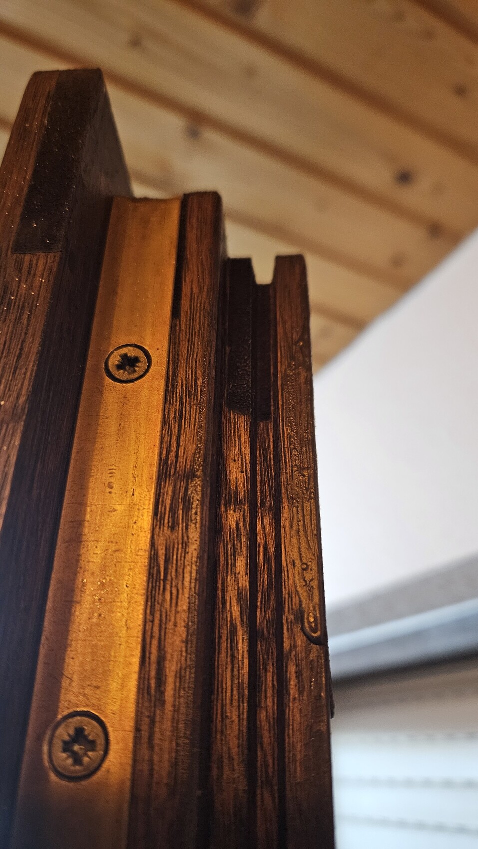 Nahaufnahme einer Holztreppe mit sichtbaren Schrauben und Holzmaserung.