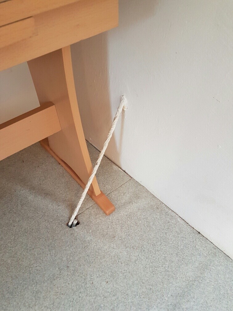 Holztreppe im Innenbereich eines Rohbaus; Seil durch Loch im Boden