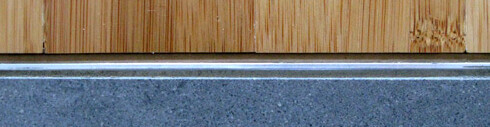 Nahaufnahme von Holzverkleidung, Metallleiste und Betonfundament