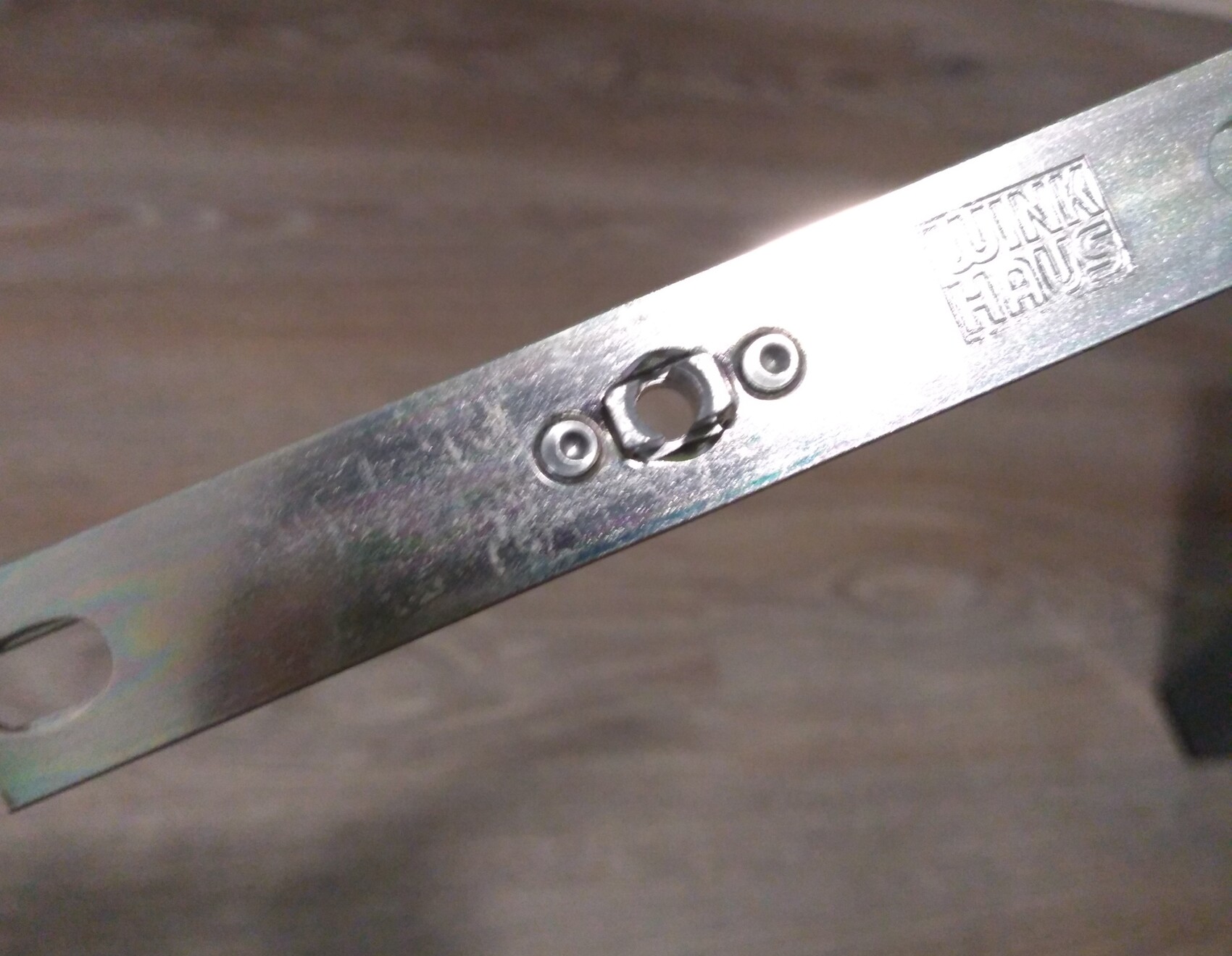 Metallband mit drei runden Öffnungen: zwei kleine Nieten und mittleres Ringloch.