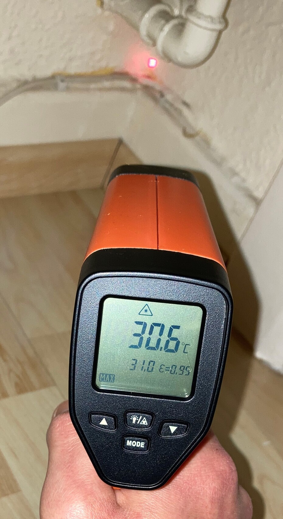 Infrarot-Thermometer orange, zeigt 30.6 °C auf Display; Kabelstecker im Hintergrund.