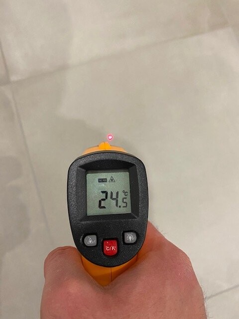 Infrarot-Thermometer in Orange misst 24,5 °C, roter Laserzielpunkt.