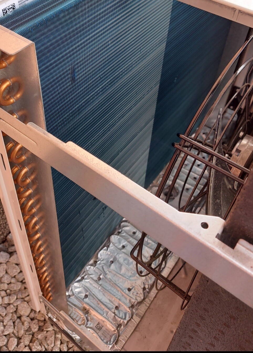 Kondensator eines Klimageräts mit blauen Kühlrippen, Kupferrohren und Metallrahmen