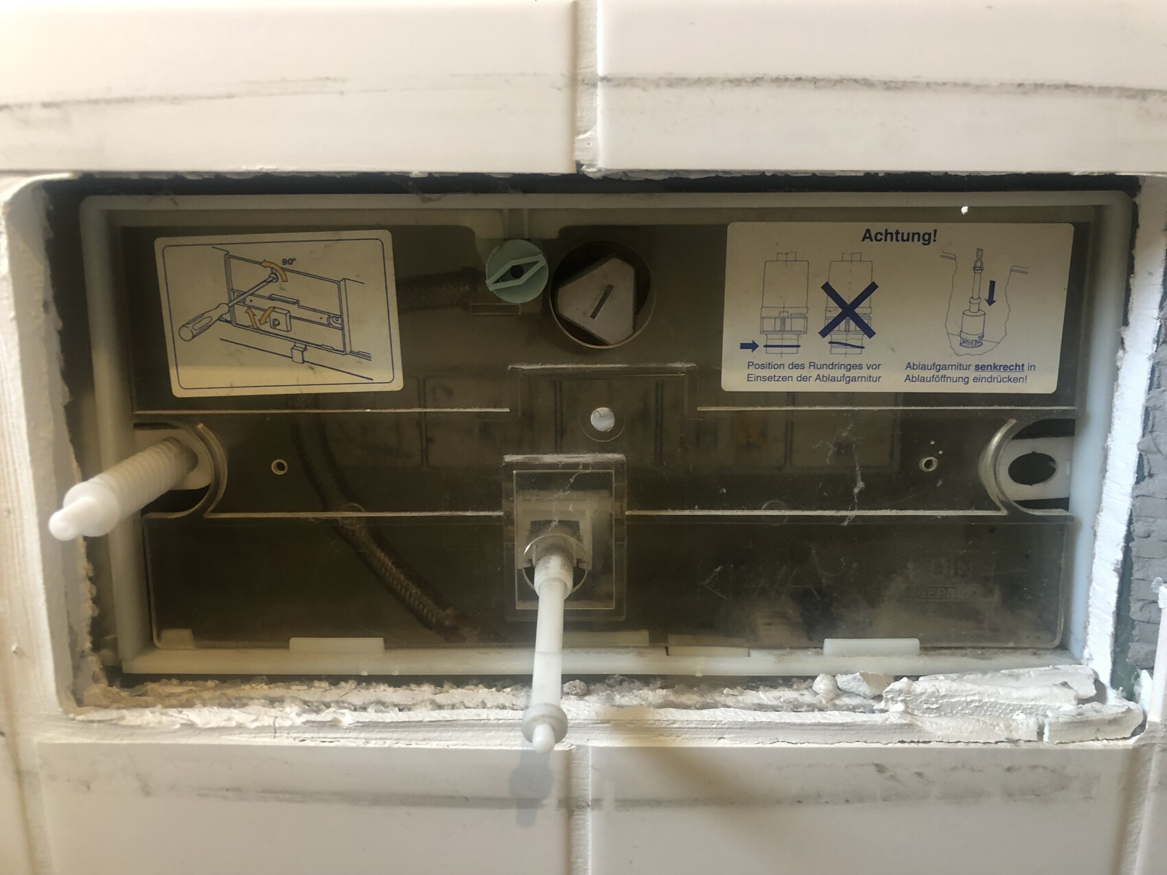 Rückseite eines Einbau-Geschirrspülers mit Schläuchen und Installationshinweisen.